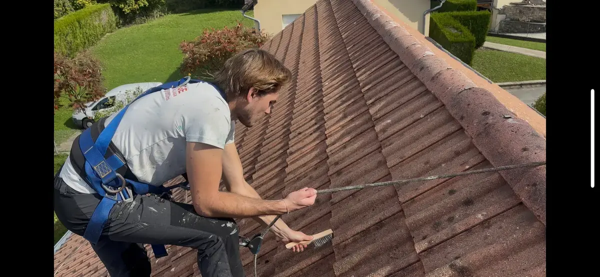 Ruben en train de nettoyer une toiture en tuiles, harnaché